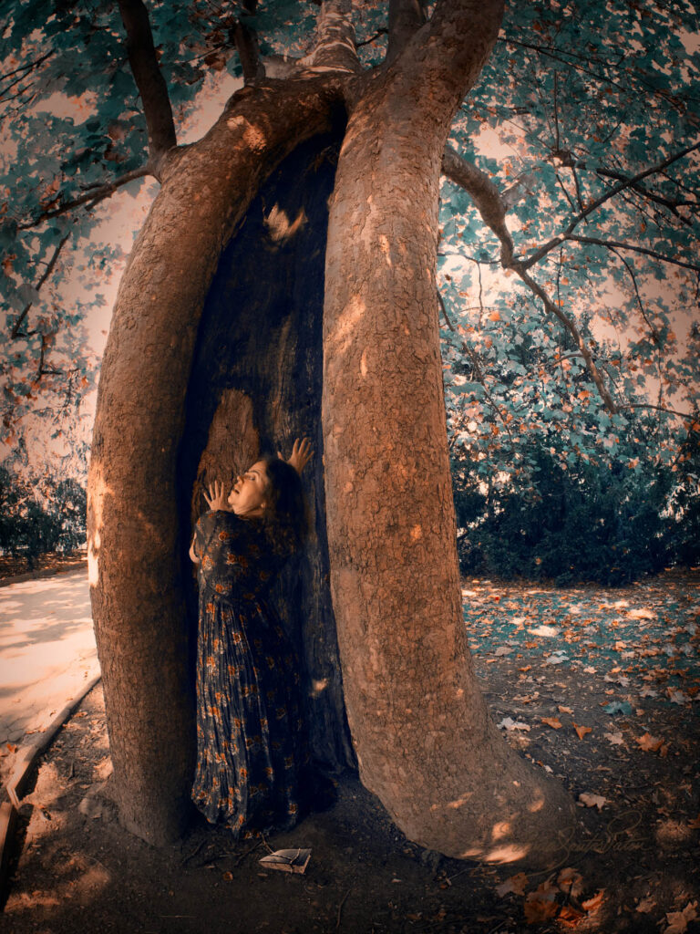 Fear expression on a woman using a tree as her protection